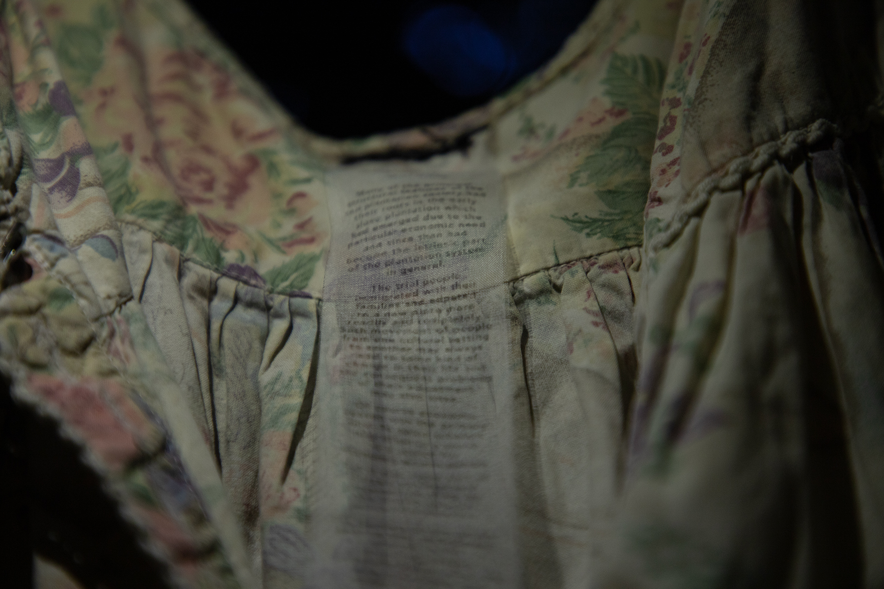 a transparent care label is visibly stitched into a faded floral dress